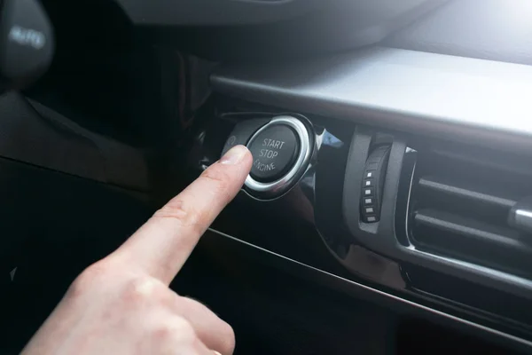 Pulse el botón de dedo funciones de arranque y parada del motor del coche en el vehículo de motor para el concepto de lista de verificación de inicio previo. Detalles interiores del coche moderno. Luz suave — Foto de Stock