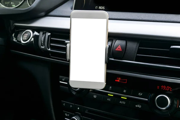 Smartphone in un uso auto per navigare o GPS. Guida di una macchina con Smartphone in titolare. Cellulare con schermo bianco isolato. Schermo vuoto vuoto. copiare spazio. Spazio vuoto per il testo. dettagli interni auto moderne . — Foto Stock