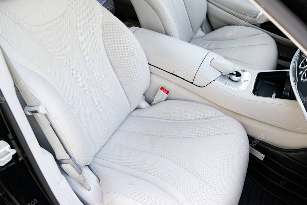 White leather interior of the luxury modern car. Leather comfortable white seats and multimedia. Steering wheel and dashboard. automatic gear stick.