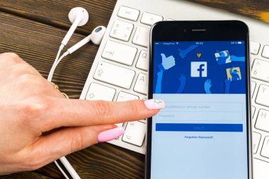 Facebook ana sayfasında monitör ekran kadın elinde ile Apple iphone 7. Ana sayfası Facebook.com smartphone cep telefonu ile 