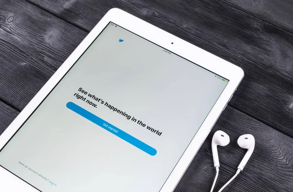 Apple iPad Pro dan earphone di atas meja kayu membuka halaman aplikasi Twitter. Twitter adalah jejaring sosial daring dan layanan mikroblog. dijalankan oleh Twitter Inc . — Stok Foto