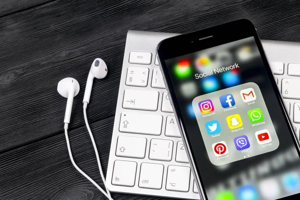Apple iPhone 7 en la mesa de madera con iconos de redes sociales Facebook, Instagram, twitter, aplicación snapchat en la pantalla. Smartphone Inicio aplicación de redes sociales . — Foto de Stock
