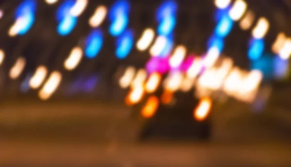Natt över staden i oskärpa. City street suddiga fotot. Gatuliv bokeh bild. Gatuvy med fotgängare och bilar oskarp bild. Vägen i stora staden bokeh bild. Night city livsstil suddiga bakgrunden — Stockfoto