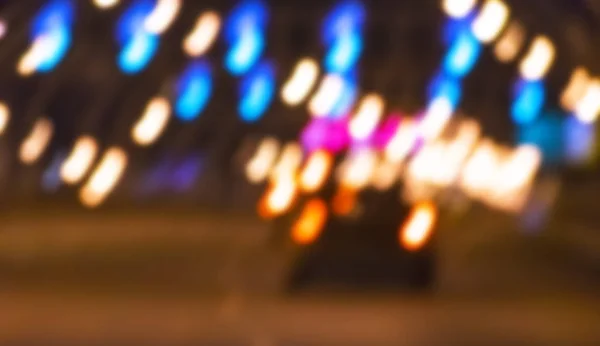 Vista nocturna de la ciudad borrosa. Foto borrosa de la calle City. La vida callejera bokeh imagen. Vista de la calle con peatones y coches imagen desenfocada. Carretera en gran ciudad bokeh imagen. Estilo de vida nocturno ciudad fondo borroso — Foto de Stock