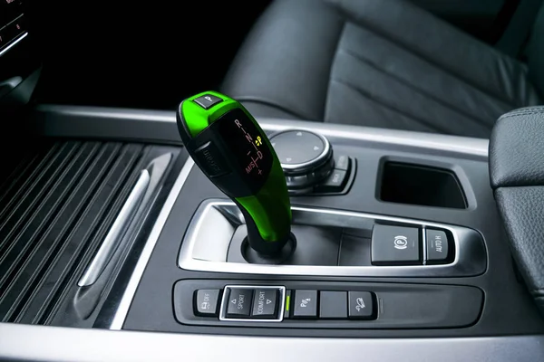 Green Automatic gear stick (transmission) of a modern car, multimedia and navigation control buttons. Car interior details. Transmission shift. — Stock Photo, Image