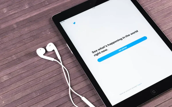 Apple iPad Pro dan earphone di atas meja kayu membuka halaman aplikasi Twitter. Twitter adalah jejaring sosial daring dan layanan mikroblog. dijalankan oleh Twitter Inc . — Stok Foto