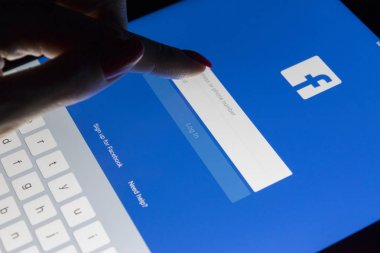 Sankt-Petersburg, Rusya, 9 Ocak 2018: Bir kadın eli Facebook ana Web sayfası ile gece ekran Tablet Apple ipad Pro dokunuyor. Facebook en büyük sosyal ağ web sitesi