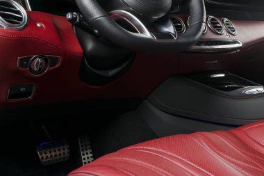Modern lüks araba içinde. Prestij modern araba iç. Konforlu deri koltuklar. Kırmızı delikli deri kokpit. Direksiyon simidi ve gösterge tablosu. otomatik vites kolu. Araba iç