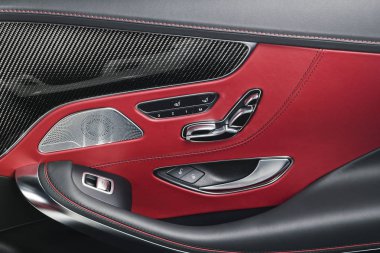Araba kırmızı deri ve karbon kapı iç ayrıntıları windows güç koltuk denetimleri ve ayarlamaları ile başa. Lüks araba içinde. Modern araba iç detaylar
