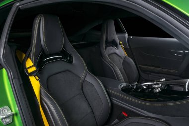 Modern lüks spor otomobil içinde. Prestij araba iç. Sarı dikişli deri koltuklar. Siyah deri delikli. Modern araba iç ayrıntılar. Otomatik vites düz vites. Ortam düğmeleri