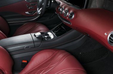 Modern lüks araba içinde. Prestij modern araba iç. Konforlu deri koltuklar. Kırmızı delikli deri kokpit. Direksiyon simidi ve gösterge tablosu. otomatik vites düz vites. Araba iç