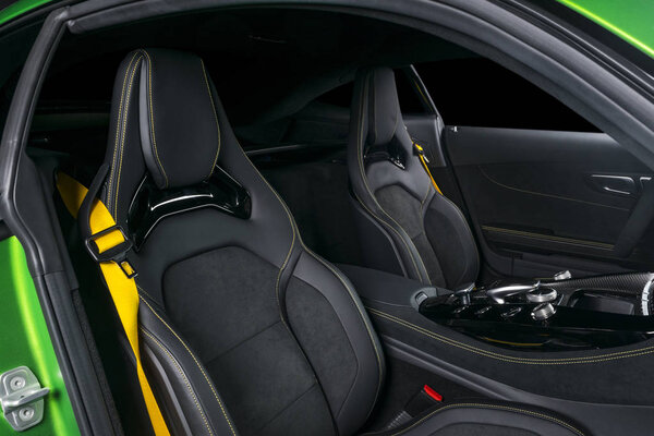 Modern Luxury sport car inside. Interior of prestige car. Leather seats with yellow stitching. Black perforated leather. Modern car interior details. Automatic gear stick shift. Media Buttons