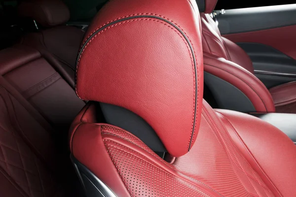 Red perforated leather driver seat with stitching inside luxury car  interior Stock Photo
