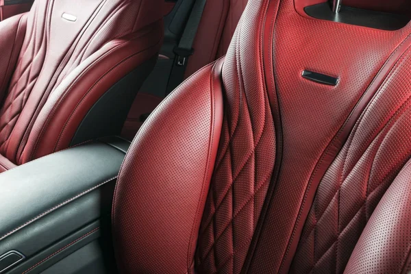 Moderno coche de lujo dentro. Interior de prestigio coche moderno. Cómodos asientos rojos de cuero. Cabina de cuero perforado rojo con fondo negro aislado. Detalles interiores del coche moderno —  Fotos de Stock
