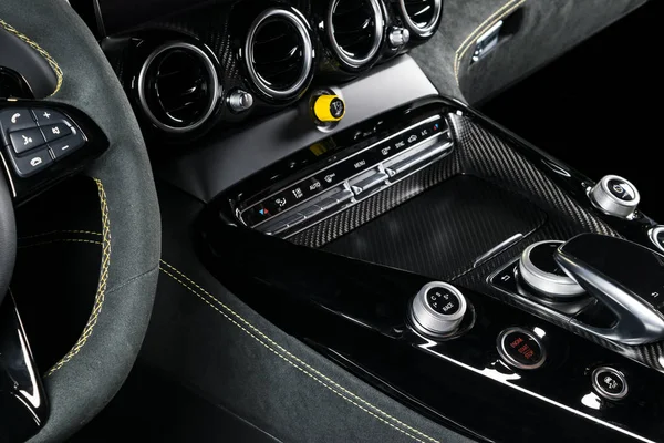 Modern Luxury car inside. Interior of prestige modern car. Comfortable leather seats. Black perforated leather with yellow stitching. Steering wheel and dashboard. automatic gear stick shift.