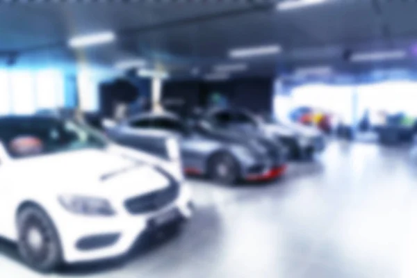 Blurred car dealership store bokeh background. Cars soft lightning. Blur bokeh transportation concept dealer showroom background. Blurry