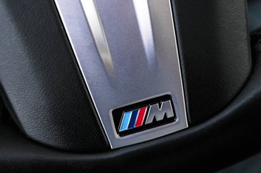 Siyah deri direksiyon spor arabasındaki BMW M logosunun yakın görüntüsü. M Performans Versiyonu. Arabanın dış detayları..