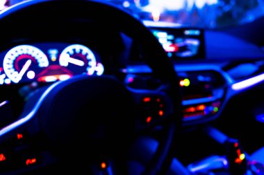 Arabanın iç kısmının bulanık görüntüsü. Gösterge paneli. Görüntü, ulaşım geçmişine odaklanmış. İçeriden araba sürüyorum. Bokeh ışık arkaplanı