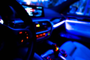 Arabanın iç kısmının bulanık görüntüsü. Gösterge paneli. Görüntü, ulaşım geçmişine odaklanmış. İçeriden araba sürüyorum. Bokeh ışık arkaplanı