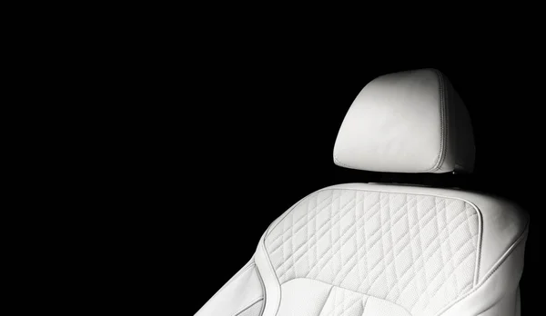 White leather interior of the luxury modern car. Perforated whitWhite leather interior of the luxury modern car. Perforated white leather comfortable seats with stitching isolated on black background. Modern car interior details. Car detailing. Car i