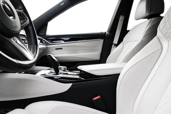 Modern luxury car white leather interior with natural wood panelModern luxury car white leather interior with natural wood panel. Part of leather car seat details with stitching. Interior of prestige modern car. White perforated leather. Car detailin