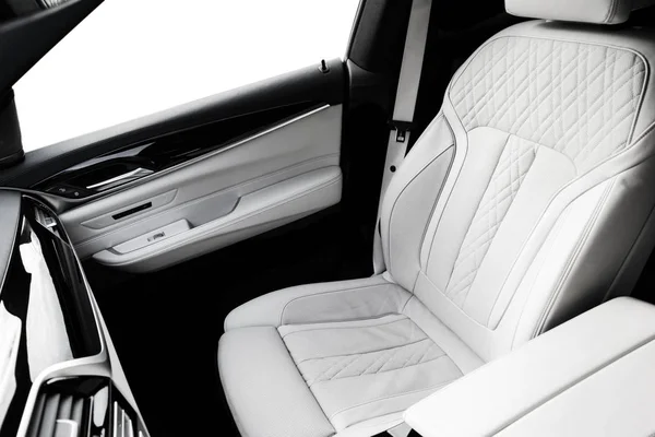 Modern luxury car white leather interior with natural wood panelModern luxury car white leather interior with natural wood panel. Part of leather car seat details with stitching. Interior with dashboard. White perforated leather. Car detailing. Car i — Stock Photo, Image