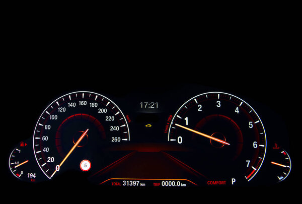 Close up shot of a red speedometer in a car. Car dashboard. Dashboard details with indication lamps.Car instrument panel. Dashboard with speedometer, tachometer, odometer. Car detailing.