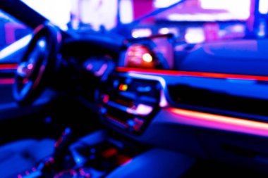 Arabanın iç kısmının bulanık görüntüsü. Gösterge paneli. Görüntü, ulaşım geçmişine odaklanmış. İçeriden araba sürüyorum. Bokeh ışık arkaplanı. Bulanık hız göstergesi ve takometre