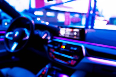 Arabanın iç kısmının bulanık görüntüsü. Gösterge paneli. Görüntü, ulaşım geçmişine odaklanmış. İçeriden araba sürüyorum. Bokeh ışık arkaplanı. Bulanık hız göstergesi ve takometre