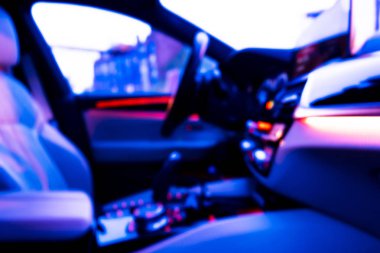 Arabanın iç kısmının bulanık görüntüsü. Gösterge paneli. Görüntü, ulaşım geçmişine odaklanmış. İçeriden araba sürüyorum. Bokeh ışık arkaplanı. Bulanık hız göstergesi ve takometre