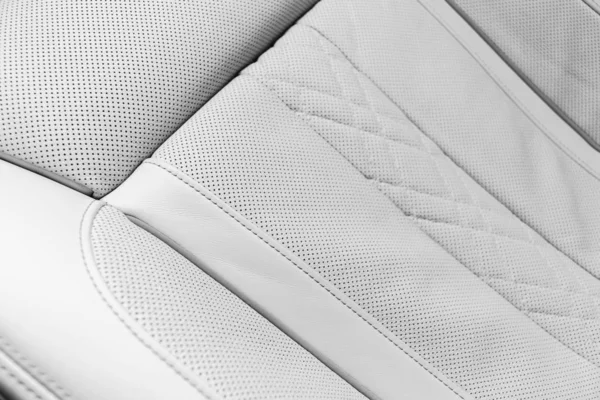 White leather interior of the luxury modern car. Perforated whitWhite leather interior of the luxury modern car. Perforated white leather comfortable seats with stitching. Modern car interior details. Car detailing. Car inside