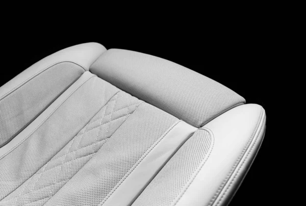 White leather interior of the luxury modern car. Perforated whitWhite leather interior of the luxury modern car. Perforated white leather comfortable seats with stitching isolated on black background. Modern car interior details. Car detailing. Car i