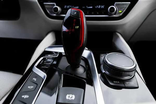 Automatic gear stick of a modern car. Modern car interior details. Close up view. Car detailing. Automatic transmission lever shift. White leather interior with stitching