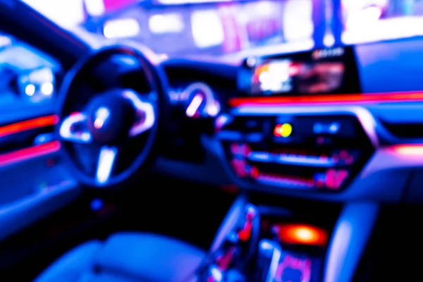 Blurred image of car interior. Dashboard. Blur defocused transportation background. Driving inside car. Bokeh light background. Blurred speedometer and tachometer