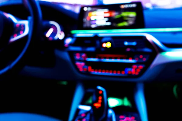 Blurred image of car interior. Dashboard. Blur defocused transportation background. Driving inside car. Bokeh light background. Blurred speedometer and tachometer