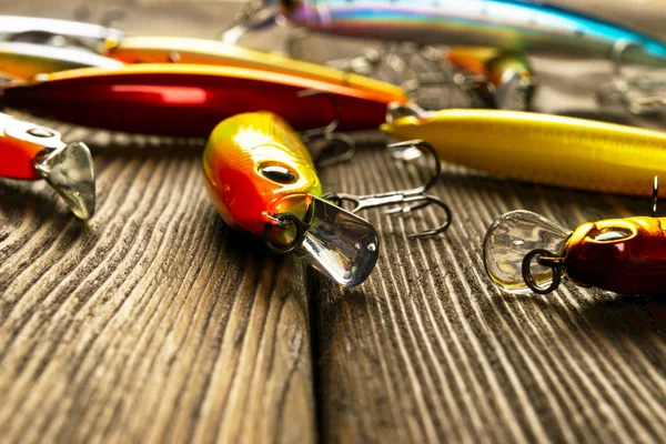 Fishing tackle background. Fishing tackles and wobbler on wooden board. Fishing hooks, lures and baits. Fishing gear on a dark table