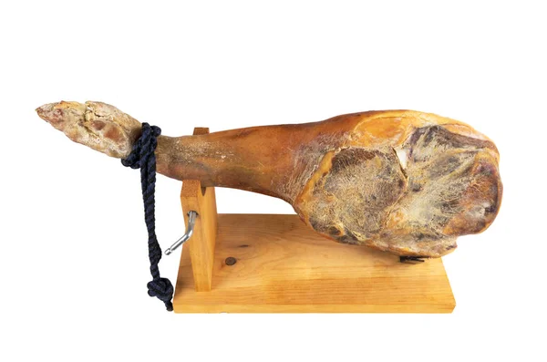 Jamon Serrano. En spansk skinka isolerad på vit bakgrund. Traditionell spansk jamon serrano ben isolerad. Torrsaltad skinka. Hela benet. Jamon på Jamonero stand — Stockfoto