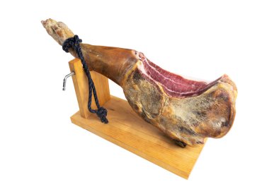 Jamon Serrano. Beyaz arka planda izole edilmiş bir İspanyol jambonu. Geleneksel İspanyol jamonu Serrano bacağı izole edildi. Kurutulmuş jambon. Bütün bacağını. Jamon jamonero standında. Hamon İberico
