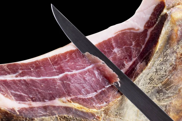 Profesyonel kesiciler, koca bir kemik serrano jambonu dilimliyor. İspanyol jambonu kesen bir bıçak. Geleneksel İspanyol jambonu kesen bir şefin elleri. Hazırlanmış balon arkaplanı dilimleniyor