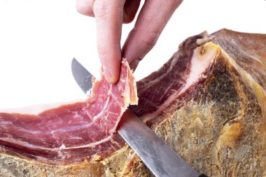 Serrano Jamon 'un tüm kemiklerini kesen profesyonel kesiciler. İspanyol jambonu kesen bir bıçak. Geleneksel İspanyol jambonu kesen bir şefin elleri. Hazırlanmış balon arkaplanı dilimleniyor