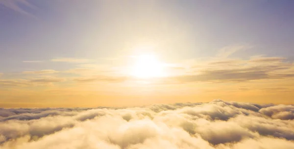 Aerial view White clouds in blue sky. Top view. View from drone.Aerial view White clouds in blue sky. Top view. View from drone. Aerial bird\'s eye view. Aerial top view cloudscape. Texture of clouds. View from above. Sunrise or sunset over clouds