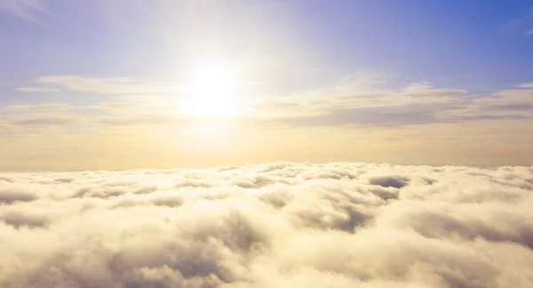 Aerial view White clouds in blue sky. Top view. View from drone.Aerial view White clouds in blue sky. Top view. View from drone. Aerial bird\'s eye view. Aerial top view cloudscape. Texture of clouds. View from above. Sunrise or sunset over clouds