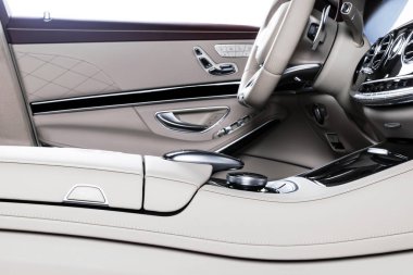 Modern lüks araba beyaz deri iç döşeme doğal ahşap panel. Deri koltuğun dikişli bir parçası. Gösterge paneliyle iç mekan. Beyaz delinmiş deri. Araba tamiri. Araba içeride.