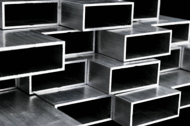 Pencere ve kapı imalatı için alüminyum profil. Yapısal metal alüminyum şekiller. Yapılar için alüminyum profil dokusu. Alüminyum inşaat fabrikası arka planı.