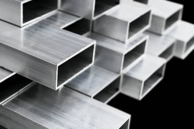Pencere ve kapı imalatı için alüminyum profil. Yapısal metal alüminyum şekiller. Yapılar için alüminyum profil dokusu. Alüminyum inşaat fabrikası arka planı.