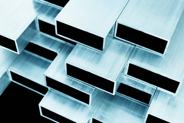 Alumínium profil ablakok és ajtók gyártásához. Szerkezeti fém alumínium formák. Alumínium profilok textúra szerkezetek. Alumíniumszerkezetek gyári háttér. — Stock Fotó