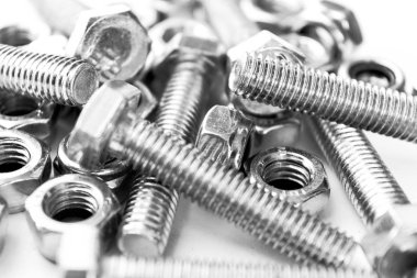 Arka planda metal cıvatalar. Krom vidalar izole edilmiş. Çelik cıvata deseni. Fındık ve cıvata seti. İş aletleri. Siyah ve beyaz
