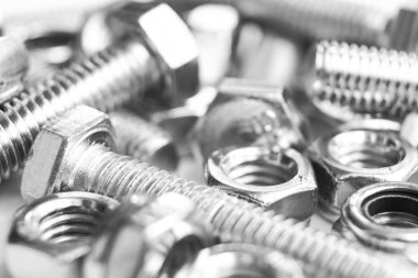 Arka planda metal cıvatalar. Krom vidalar izole edilmiş. Çelik cıvata deseni. Fındık ve cıvata seti. İş aletleri. Siyah ve beyaz