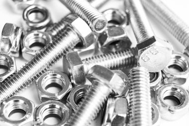 Arka planda metal cıvatalar. Krom vidalar izole edilmiş. Çelik cıvata deseni. Fındık ve cıvata seti. İş aletleri. Siyah ve beyaz