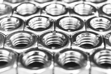 Arka planda metal somunlar. Krom vidalı somunlar izole. Çelik somun deseni. Somun ve cıvata seti. İş için araçlar. Siyah beyaz